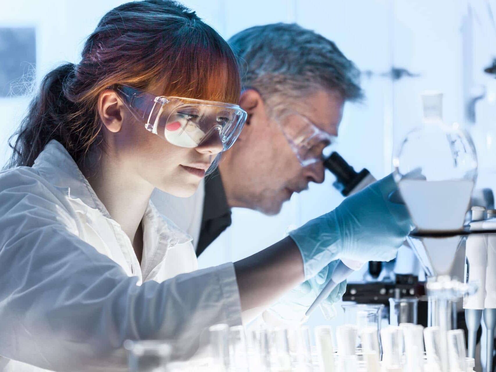 Uma mulher e um homem analisando amostras em um laboratório