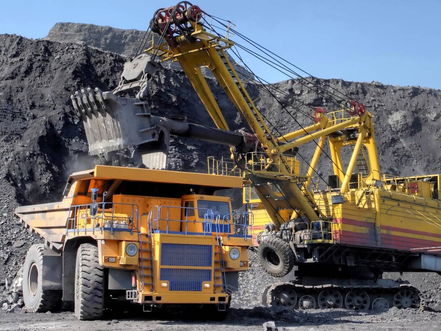 Grande máquina amarela operando em uma mineração